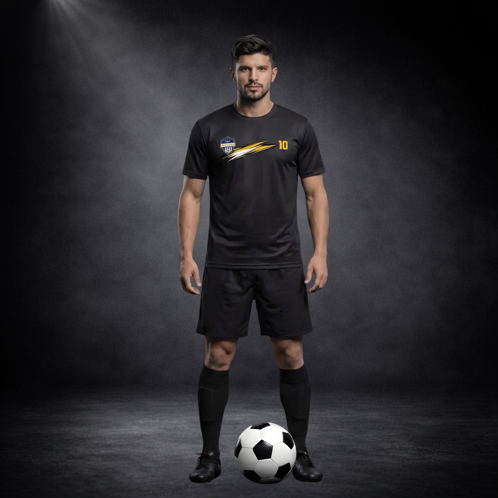 Ganzkörperaufnahme eines männlichen Models im schwarzen Fußball-Set mit CERTANU-Logo, goldenen Designelementen und Nummer 10, steht frontal mit einem Fußball vor den Füßen, vor dunklem Studio-Hintergrund mit Spotlight