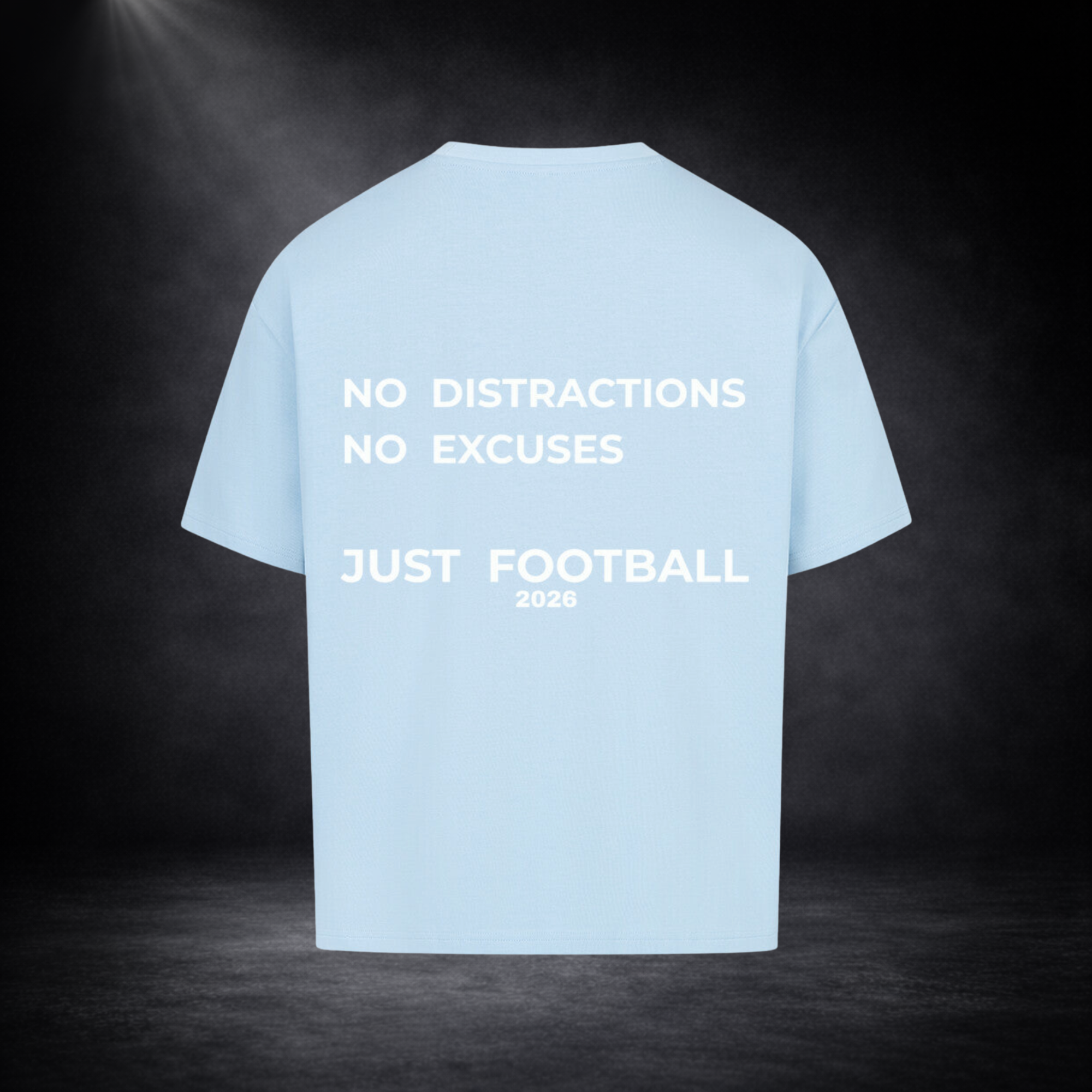Hellblaues Oversized T-Shirt Rückseite mit großem weißen Statement-Print „No Distractions No Excuses Just Football 2026“, freigestelltes Produktbild auf dunklem Studio-Hintergrund, minimalistisches Streetwear Design