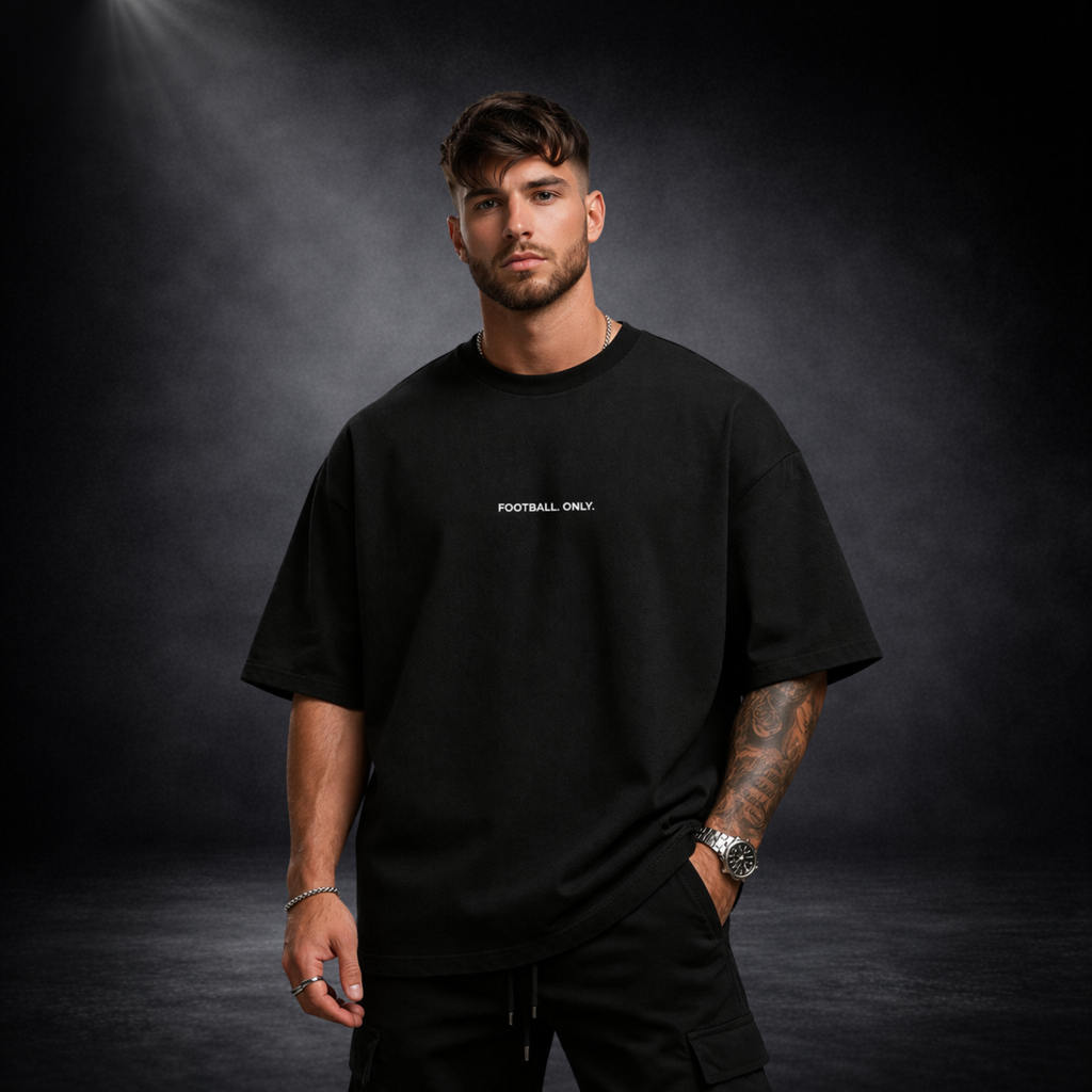Schwarzes Oversized T-Shirt mit „Football Only“ Schriftzug, Model Frontansicht, minimalistisches Premium Streetwear Design auf dunklem Studiohintergrund