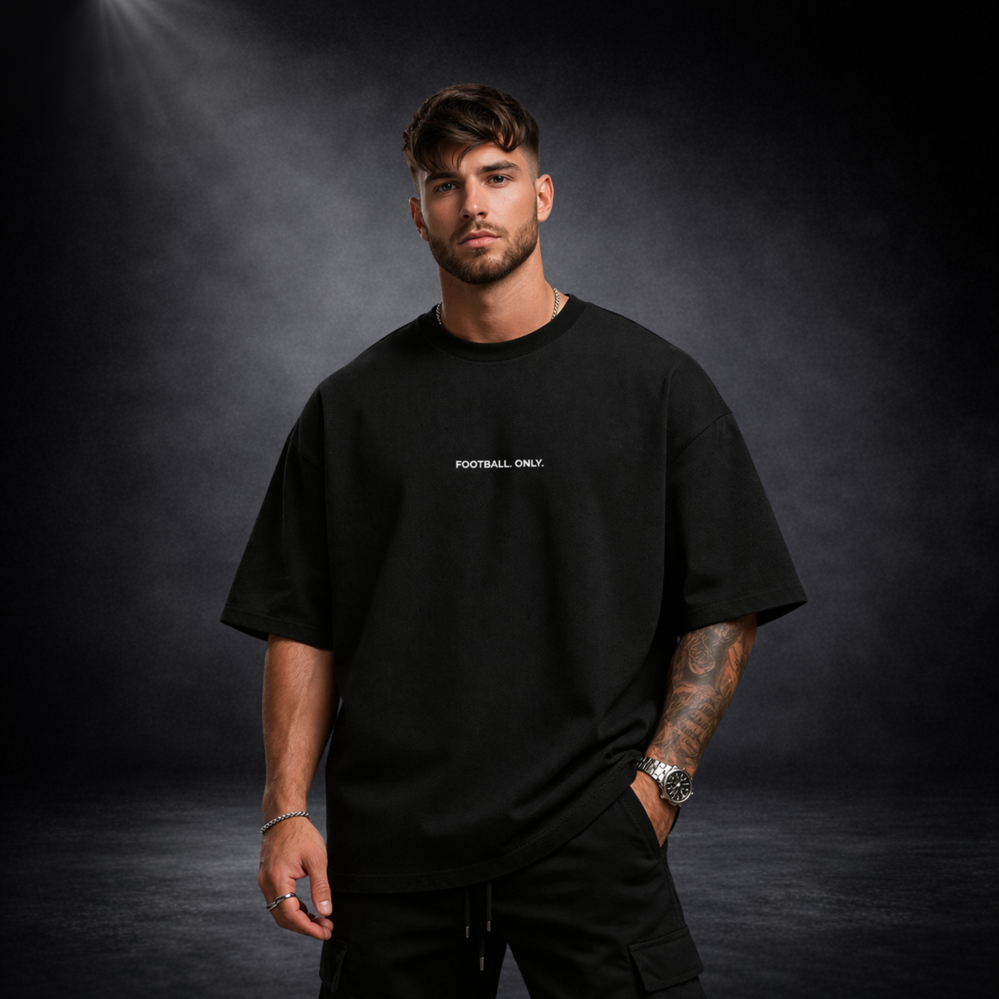Schwarzes Oversized T-Shirt mit „Football Only“ Schriftzug, Model Frontansicht, minimalistisches Premium Streetwear Design auf dunklem Studiohintergrund
