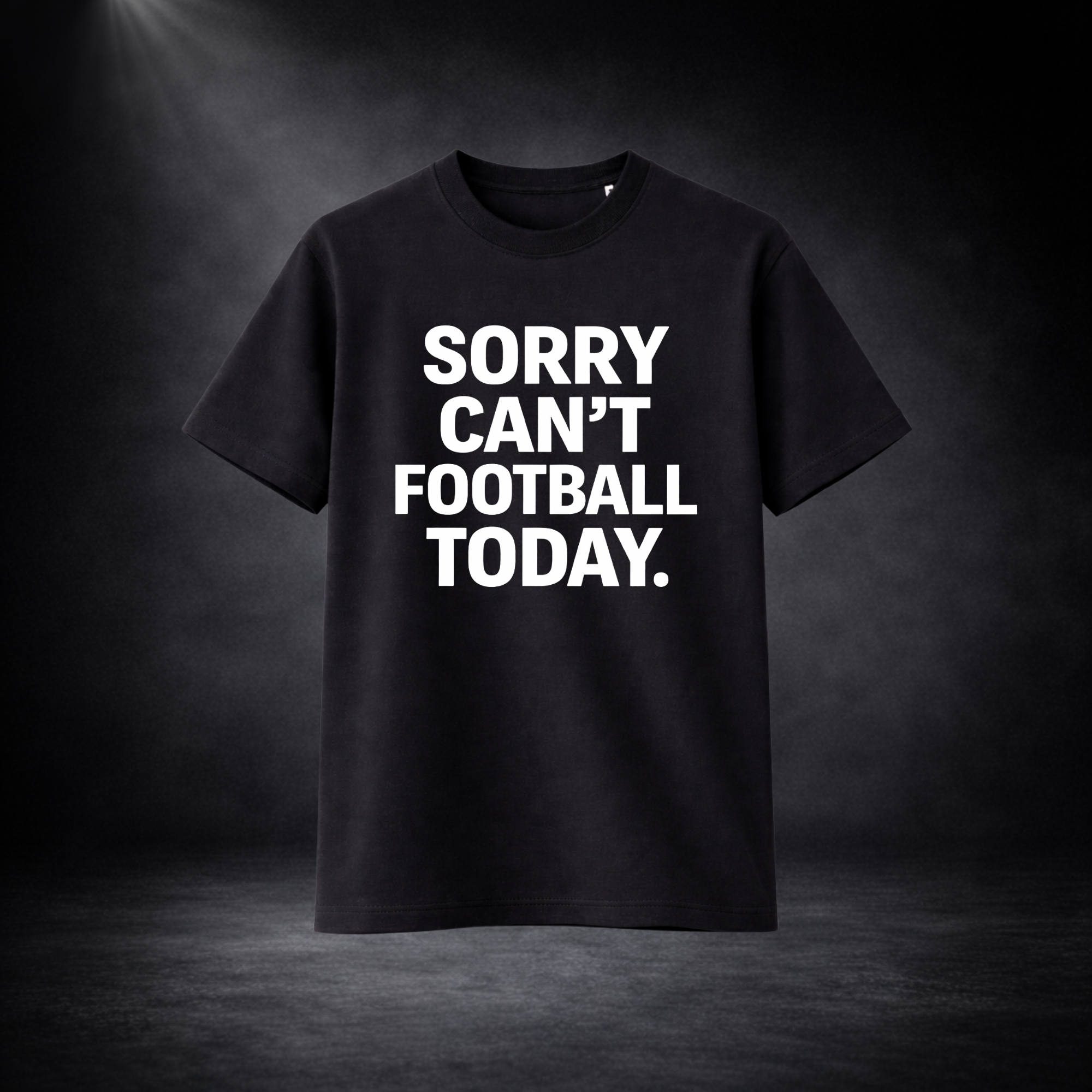 Schwarzes T-Shirt vor dunklem Studio-Hintergrund, frontal dargestellt, mit großem weißem Aufdruck „SORRY CAN’T FOOTBALL TODAY.“ in auffälliger, klarer Typografie