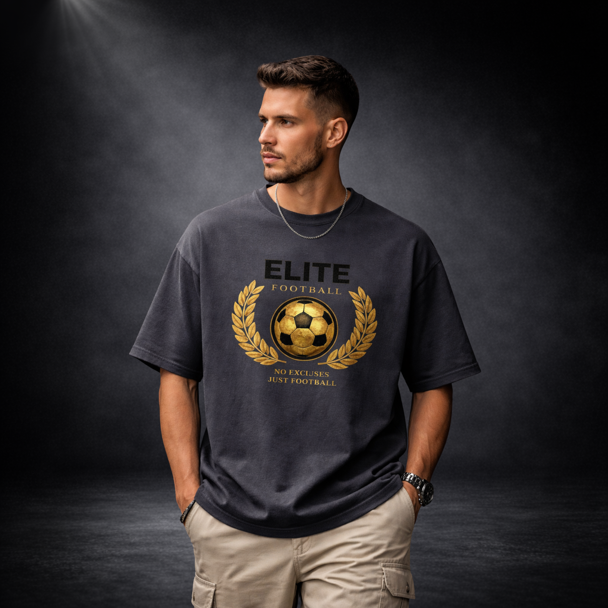 Herren Oversized T-Shirt schwarz mit goldenem „Elite Football“ Fußball-Print, Model Frontansicht, Premium Streetwear auf dunklem Studiohintergrund