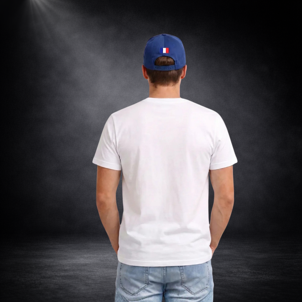 Rückansicht eines jungen Mannes mit weißem T-Shirt ohne Aufdruck, kombiniert mit Jeans und blauer Cap mit kleiner Frankreich-Flagge, vor dunklem Studio-Hintergrund