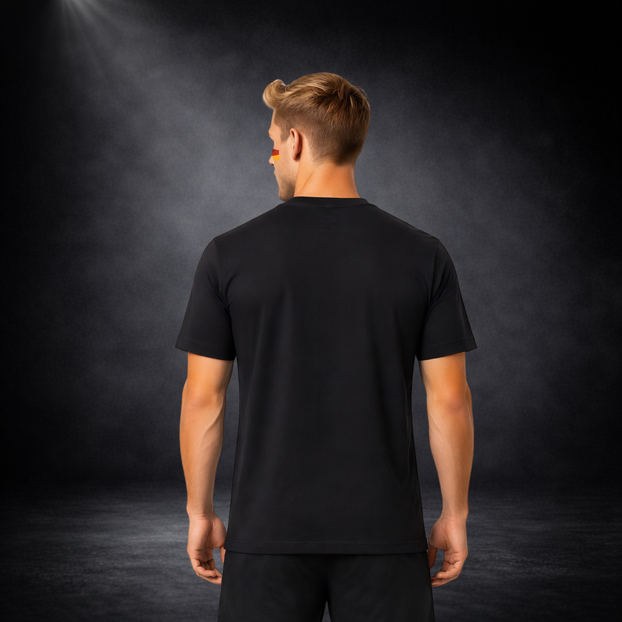 Rückansicht eines jungen Mannes mit schwarzem T-Shirt ohne Druck, Deutschland Fußball Fan Outfit, schlichtes Herren Shirt für WM 2026, Studioaufnahme auf dunklem Hintergrund