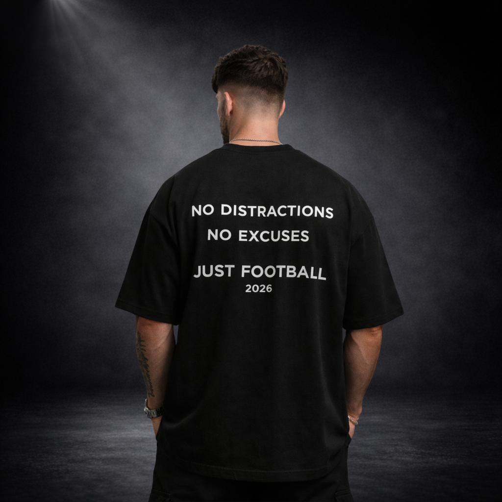 Schwarzes Oversized T-Shirt Rückansicht mit „No Distractions No Excuses Just Football 2026“ Print, Model frontal von hinten auf dunklem Studiohintergrund, Premium Streetwear Design