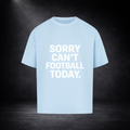 Hellblaues Oversized T-Shirt mit großem weißen Schriftzug „SORRY CAN’T FOOTBALL TODAY.“ auf der Vorderseite, präsentiert vor dunklem Studio-Hintergrund mit Spotlight-Beleuchtung