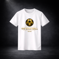 Weißes T-Shirt mit goldenem Fußball-Logo und dem Schriftzug „THE GOLD BALL 2026“ auf der Vorderseite, freigestellt vor dunklem Studio-Hintergrund mit Spotlight-Effekt