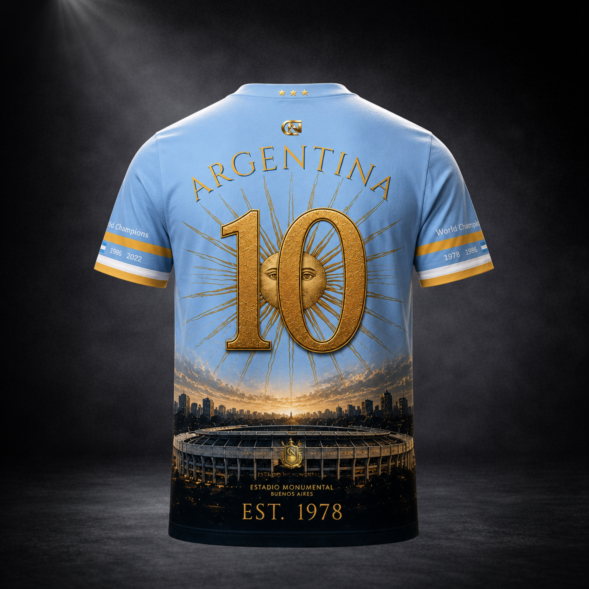 Rückansicht eines hellblauen Argentinien-Fanshirts von CERTANU vor dunklem Premium-Studiohintergrund. Das exklusive Rückenmotiv zeigt den Schriftzug „ARGENTINA“ über einer großen goldenen Nummer 10, die vor der ikonischen Sonne der argentinischen Flagge platziert ist. Im unteren Bereich befinden sich das Estadio Monumental von Buenos Aires, eine moderne Skyline sowie die goldene Jahreszahl „EST. 1978“ als Hommage an den ersten Weltmeistertitel Argentiniens. Die Ärmel tragen die Weltmeisterjahre 1978, 1986 u