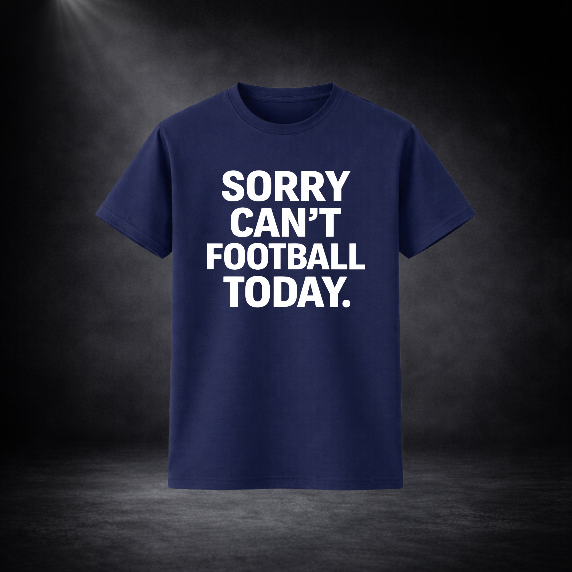 Blaues T-Shirt mit großem weißen Schriftzug „SORRY CAN’T FOOTBALL TODAY.“ auf der Vorderseite, freigestellt vor dunklem Studio-Hintergrund mit Spotlight von oben links