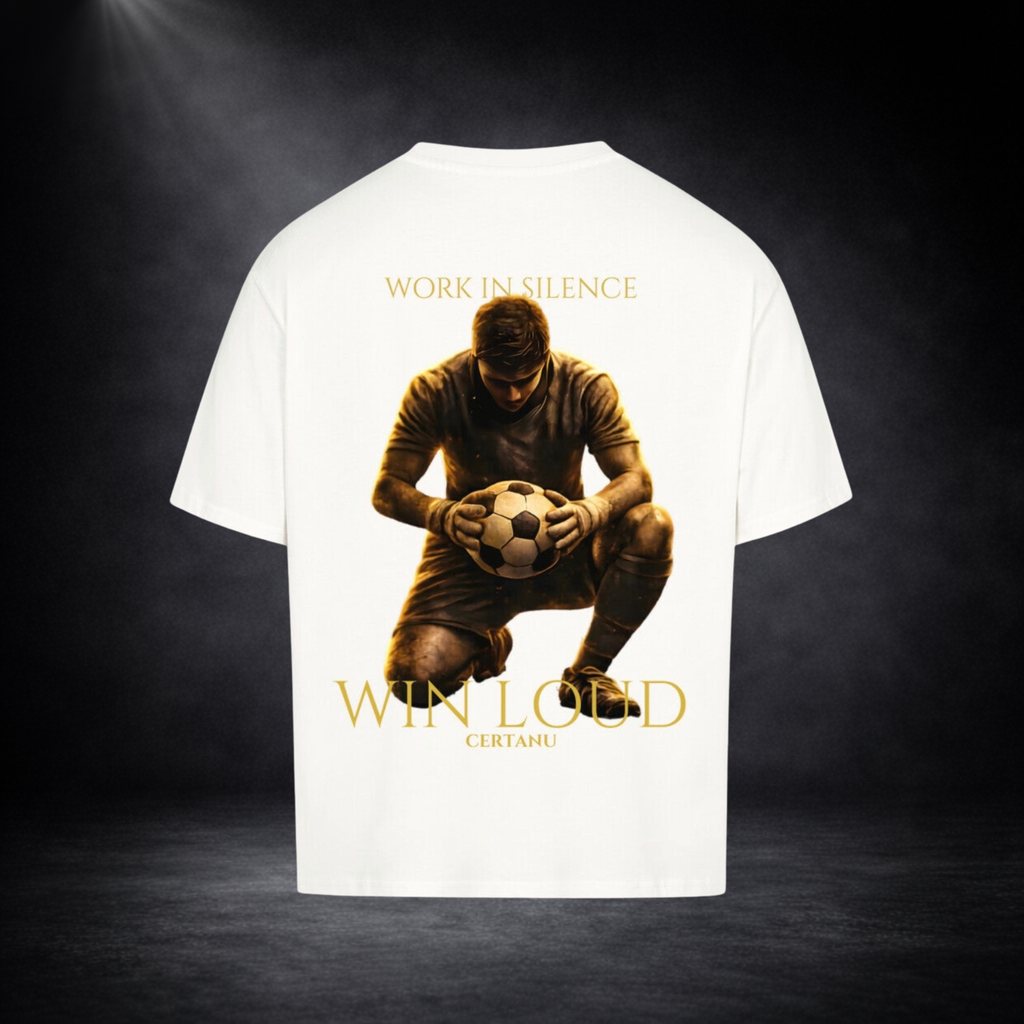Weises oversized T-Shirt in Rückansicht mit großem goldenem Motiv eines knienden Fußballspielers mit Ball, Schriftzug „WORK IN SILENCE“ oben und „WIN LOUD CERTANU“ unten, vor dunklem Studio-Hintergrund