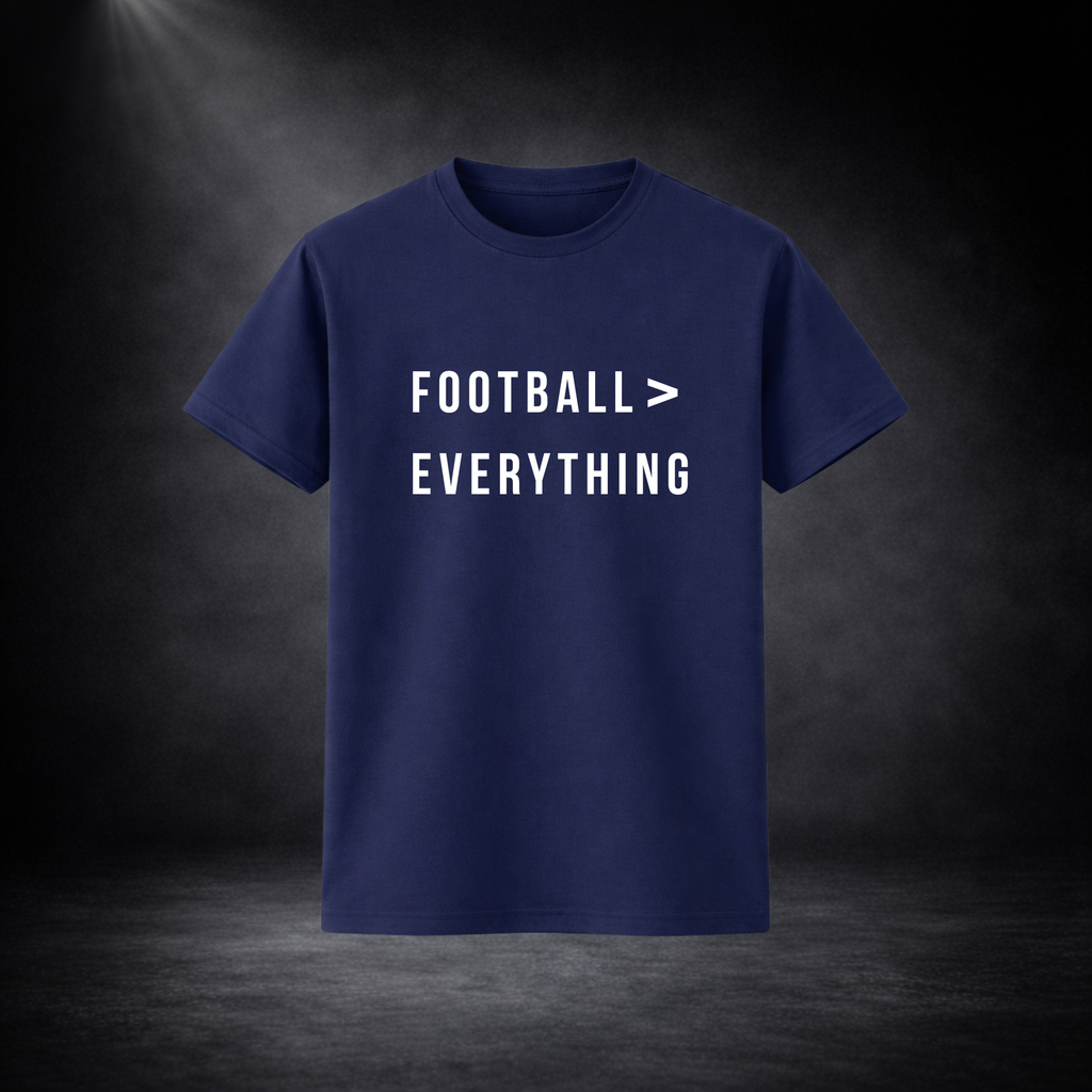 Dunkelblaues T-Shirt vor dunklem Studio-Hintergrund, frontal dargestellt, mit weißem Schriftzug „FOOTBALL > EVERYTHING“ in klarer, moderner Typografie