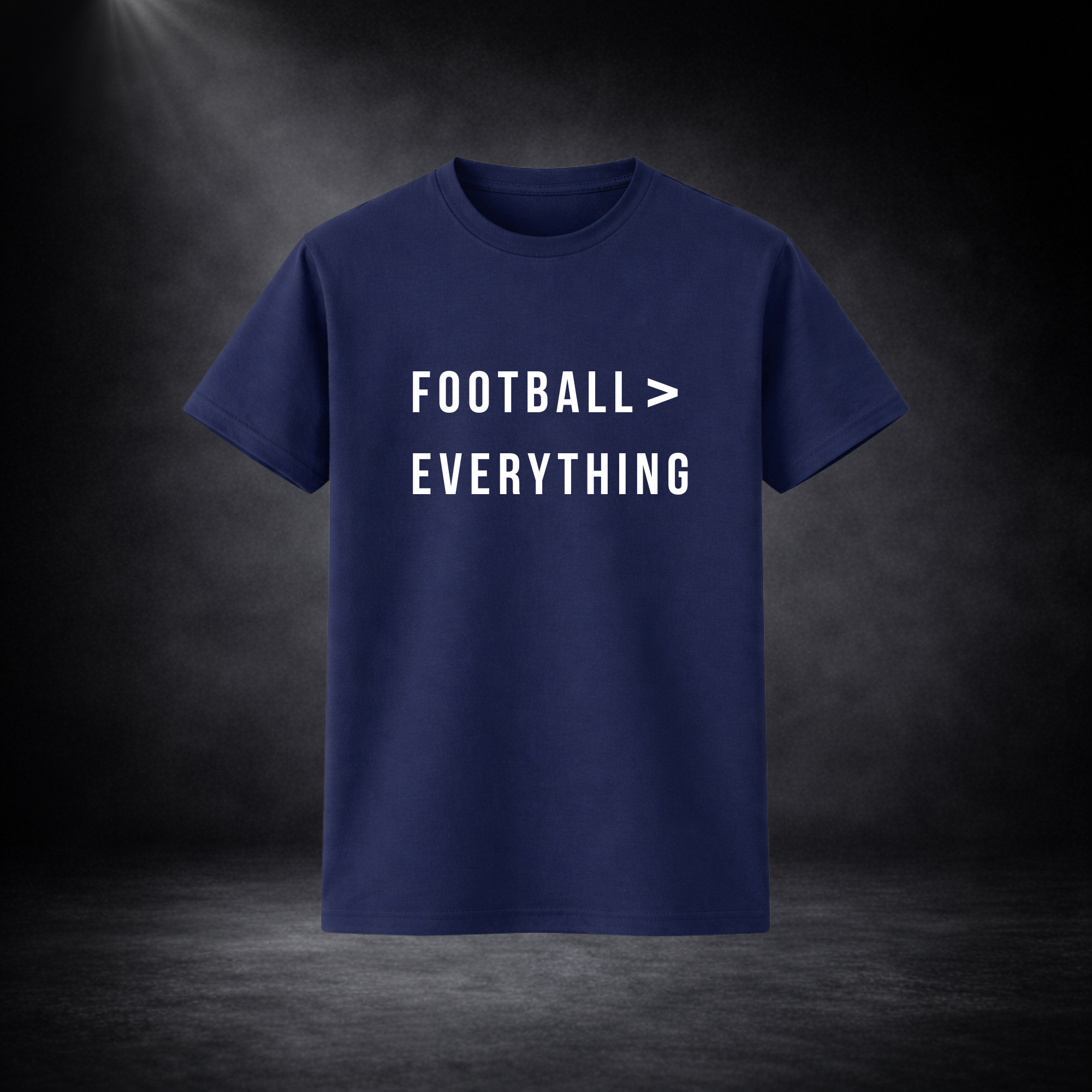 Dunkelblaues T-Shirt vor dunklem Studio-Hintergrund, frontal dargestellt, mit weißem Schriftzug „FOOTBALL > EVERYTHING“ in klarer, moderner Typografie
