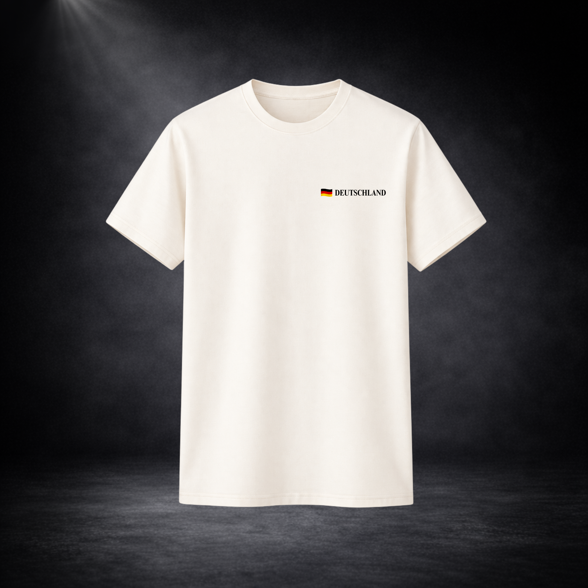 Beiges Deutschland Fan T-Shirt mit kleinem „Deutschland“-Schriftzug und Flagge auf der Brust, minimalistisches Fußball WM 2026 Design vor dunklem Studio Hintergrund