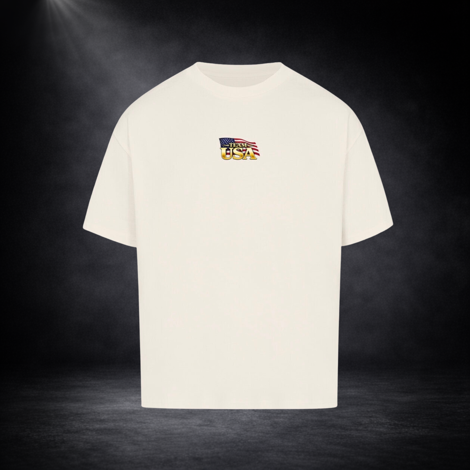 Beiges oversized T-Shirt Vorderseite mit kleinem „Team USA“-Logo auf der Brust, US-Flaggen-Element, dunkler Studio-Hintergrund