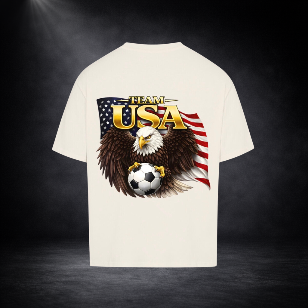Beiges oversized T-Shirt Rückseite mit großem „Team USA“-Print, Adler mit Fußball vor US-Flagge, dunkler Studio-Hintergrund