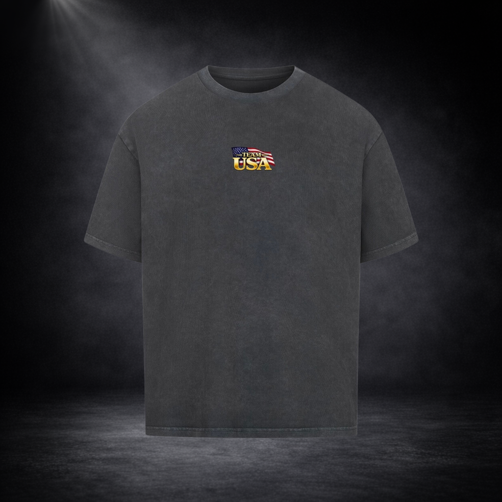 Dunkelgraues oversized T-Shirt Vorderseite mit kleinem „Team USA“-Logo auf der Brust, US-Flaggen-Element, dunkler Studio-Hintergrund