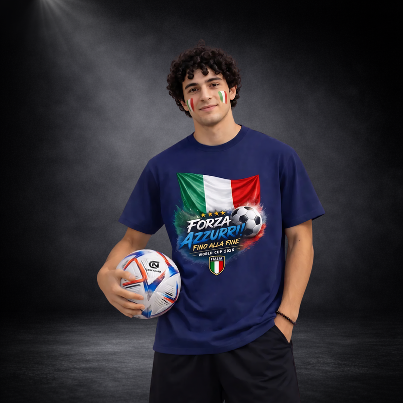 Junger Mann mit Italien-Fanbemalung im Gesicht trägt blaues T-Shirt mit „Forza Azzurri – Fino Alla Fine World Cup 2026“-Design, italienischer Flagge und Fußball, hält einen Ball in der Hand vor dunklem Studiohintergrund