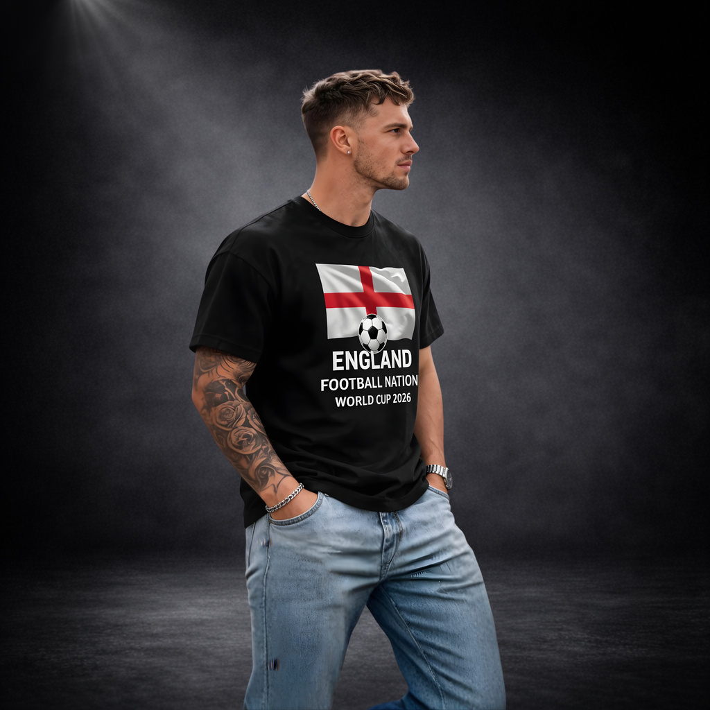Männliches Model trägt ein schwarzes T-Shirt mit England-Flagge und Fußballmotiv sowie dem Schriftzug „England Football Nation World Cup 2026“, vor dunklem Studio-Hintergrund in seitlicher Pose