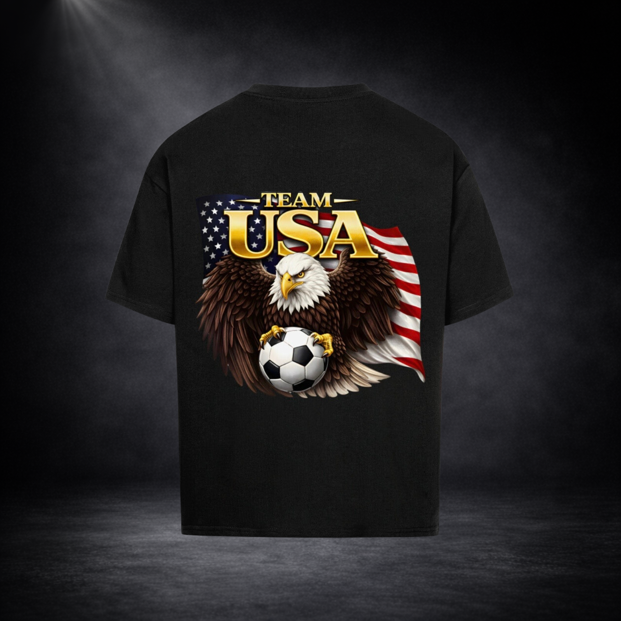 Schwarzes Oversized T-Shirt Rückseite mit großem „Team USA“-Print, Adler mit ausgebreiteten Flügeln hält einen Fußball vor US-Flagge, dunkler Studio-Hintergrund