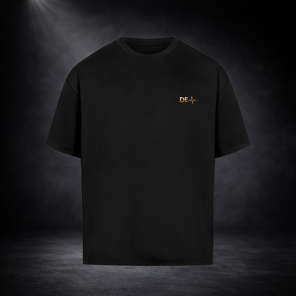 Schwarzes T-Shirt vor dunklem Studio-Hintergrund, minimalistisch präsentiert mit kleinem goldenen Brustlogo, cleanes und hochwertiges Design