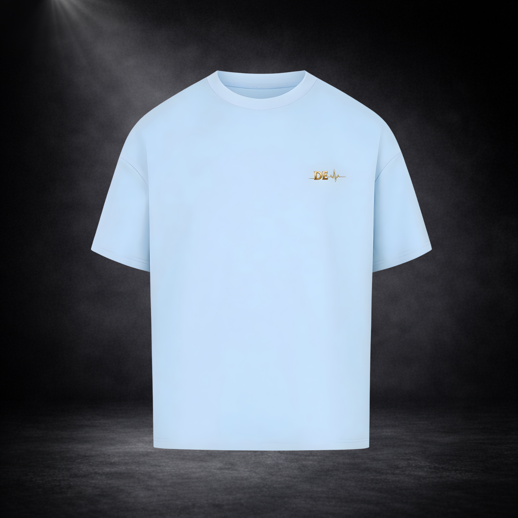 Hellblaues T-Shirt vor dunklem Studio-Hintergrund, minimalistisch dargestellt mit kleinem goldenen Brustlogo, cleanes und modernes Design