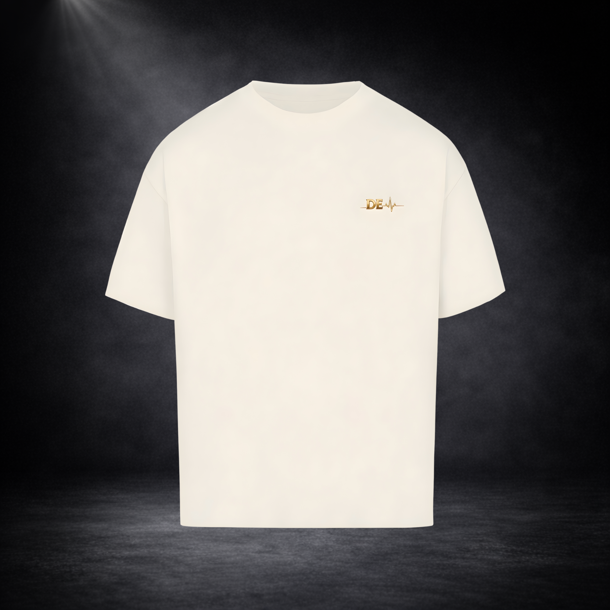 Beiges T-Shirt vor dunklem Studio-Hintergrund, minimalistisch dargestellt mit kleinem goldenen Brustlogo, cleanes und hochwertiges Design