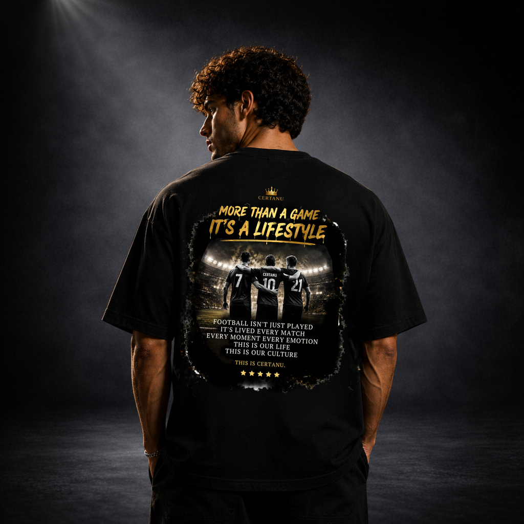 Junger Mann trägt ein schwarzes CERTANU Oversized Football T-Shirt mit großem Rückenprint. Das Design zeigt drei Fußballspieler im Stadion mit dem Schriftzug „More Than A Game – It’s A Lifestyle“ und goldenen Akzenten. Premium Fußball Streetwear für Herren, moderner Fan-Look, hochwertiges Backprint-Shirt für Fußballfans, Lifestyle- und Stadionmode im urbanen Stil.