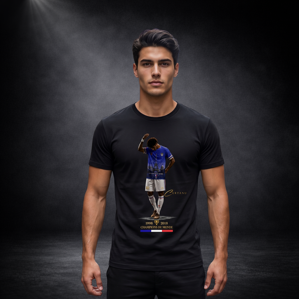 Männliches Model trägt ein schwarzes CERTANU T-Shirt vor einem dunklen Studiohintergrund mit dramatischer Spotlight-Beleuchtung. Das Fußball-Design auf der Brust zeigt einen Spieler im blauen Frankreich-Trikot mit Eiffelturm-Motiv sowie den Schriftzug „Champions du Monde“ und die Weltmeisterjahre 1998 und 2018. Goldene CERTANU-Details und die französischen Nationalfarben verleihen dem Motiv einen hochwertigen Premium-Look. Das moderne schwarze Fan-Shirt kombiniert Fußballkultur, französische Nationalstolz-M