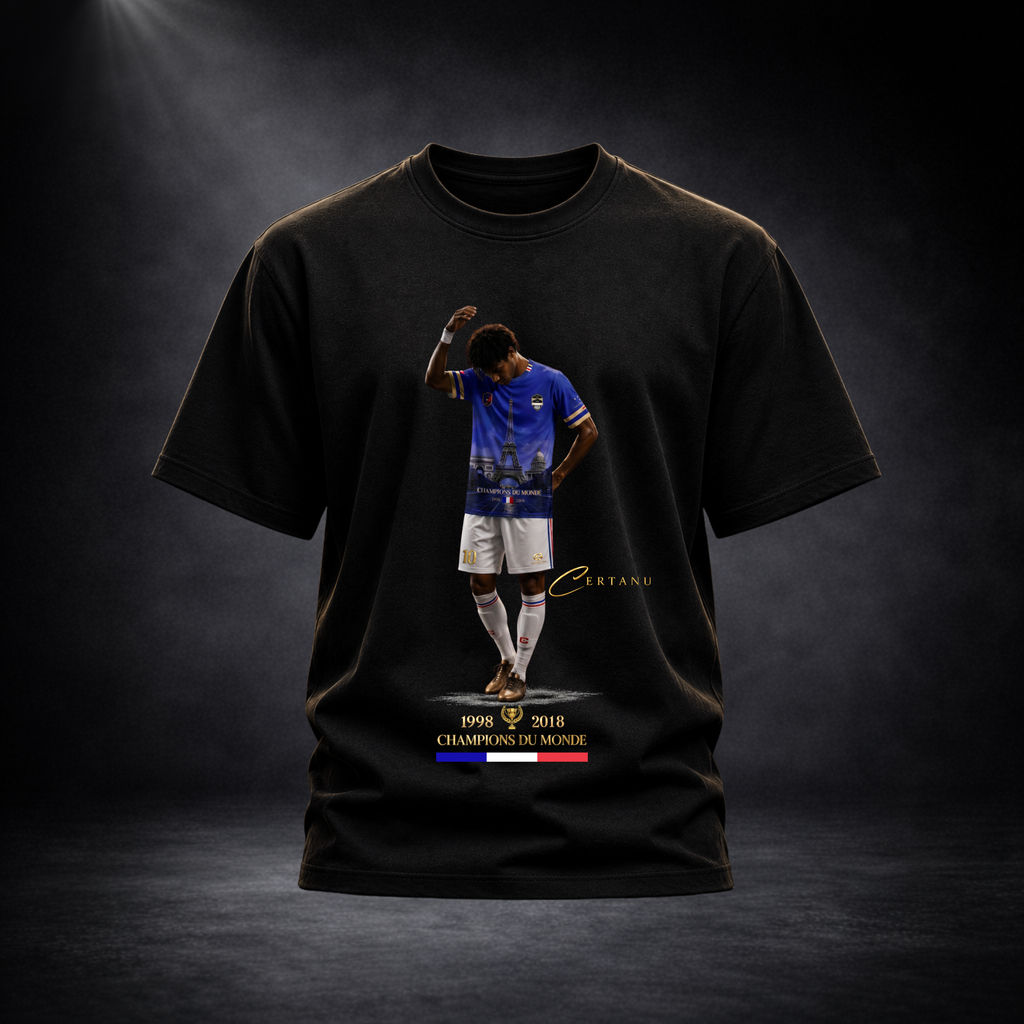 Produktaufnahme eines schwarzen CERTANU Premium T-Shirts vor dunklem Studiohintergrund mit edler Spotlight-Beleuchtung. Auf der Vorderseite befindet sich ein exklusives Frankreich-Fußballmotiv mit einem Spieler im blauen Trikot, integriertem Eiffelturm-Design und goldenen CERTANU-Details. Unter dem Motiv stehen die Weltmeisterjahre 1998 und 2018 sowie der Schriftzug „Champions du Monde“ mit französischer Trikolore in Blau, Weiß und Rot. Das hochwertige Fan-Shirt verbindet moderne Streetwear mit französische