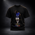 Produktaufnahme eines schwarzen CERTANU Premium T-Shirts vor dunklem Studiohintergrund mit edler Spotlight-Beleuchtung. Auf der Vorderseite befindet sich ein exklusives Frankreich-Fußballmotiv mit einem Spieler im blauen Trikot, integriertem Eiffelturm-Design und goldenen CERTANU-Details. Unter dem Motiv stehen die Weltmeisterjahre 1998 und 2018 sowie der Schriftzug „Champions du Monde“ mit französischer Trikolore in Blau, Weiß und Rot. Das hochwertige Fan-Shirt verbindet moderne Streetwear mit französische