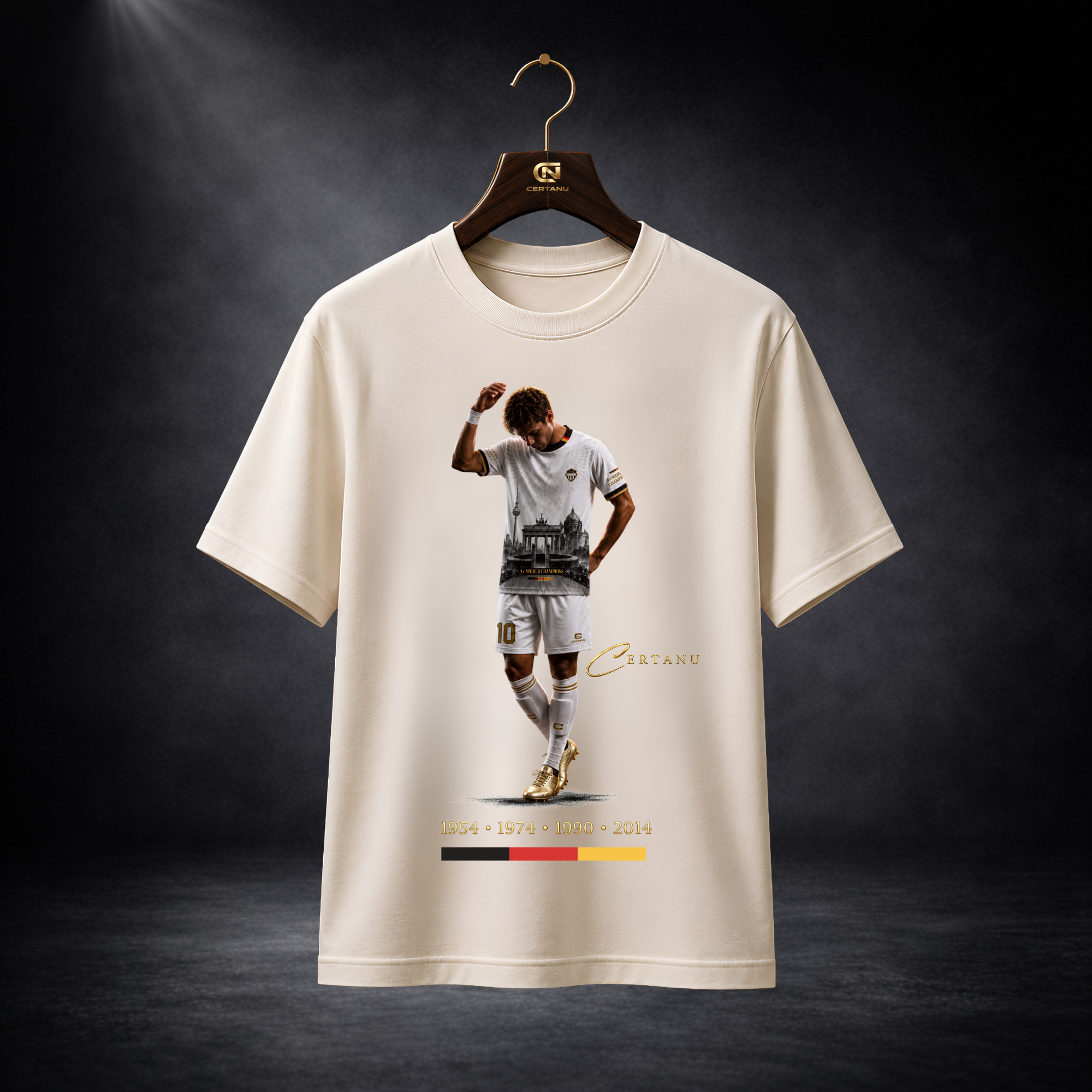 Weißes CERTANU Deutschland Fan-Shirt auf edlem Holzkleiderbügel vor dunklem Studiohintergrund. Das exklusive Fußball-Design zeigt einen Spieler im weißen Trikot mit goldenen Schuhen sowie eine stilisierte Berliner Skyline mit Brandenburger Tor. Unter dem Motiv sind die deutschen Weltmeisterjahre 1954, 1974, 1990 und 2014 sowie die Nationalfarben Schwarz, Rot und Gold abgebildet. Hochwertiges Produktbild für Shopify, Google Shopping und E-Commerce. Modernes Deutschland Fan-Shirt im Premium Streetwear-Stil fü