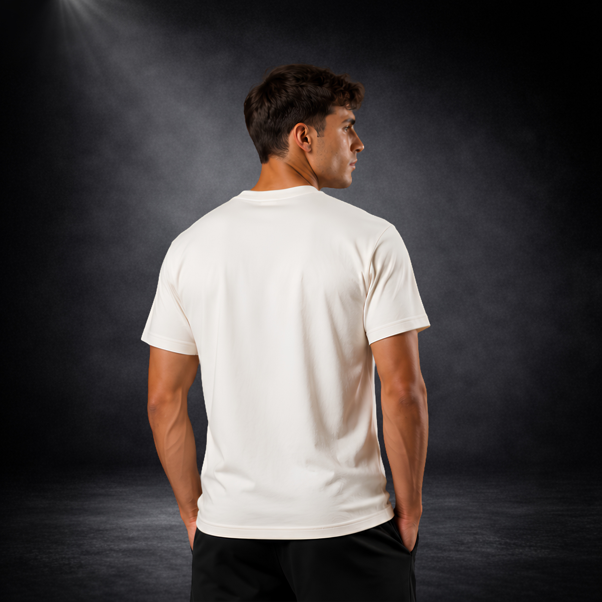 Rückansicht eines jungen männlichen Models in einem cremeweißen CERTANU Deutschland Fan-Shirt vor dunklem Studiohintergrund mit dezenter Spotlight-Beleuchtung. Das T-Shirt wird von hinten präsentiert und zeigt die schlichte, unbedruckte Rückseite mit moderner Passform und sauberem Schnitt. Kombiniert mit schwarzen Shorts entsteht ein sportlich-eleganter Fußball-Lifestyle-Look. Die hochwertige Verarbeitung, der angenehme Tragekomfort und das minimalistische Design machen das Shirt ideal für Deutschland-Fans,