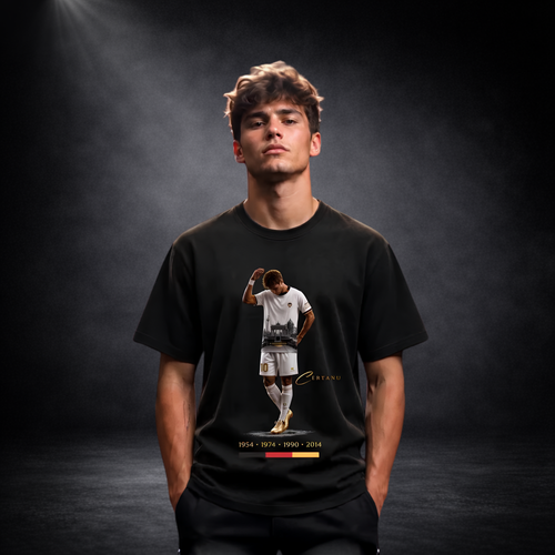 Junger Mann trägt ein schwarzes CERTANU Premium T-Shirt mit exklusivem Fußballspieler-Motiv in einem dunklen Studio. Das Design zeigt einen Fußballspieler im weißen Trikot mit gesenktem Kopf vor einer stilisierten Stadionszene sowie den Jahreszahlen 1954, 1974, 1990 und 2014 als Hommage an die deutschen Weltmeistertitel. Goldene Details und dezentes CERTANU-Logo verleihen dem Shirt einen hochwertigen Streetwear-Look. Das moderne Baumwoll-T-Shirt eignet sich ideal für Fußballfans, Freizeit, Stadionbesuche, S
