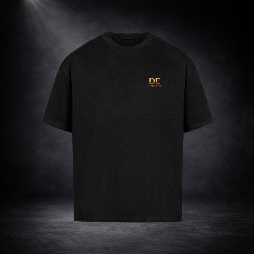 Schwarzes Oversized T-Shirt mit kleinem goldenen „DE Germany“ Logo auf der Brust, freigestellt vor dunklem Studio-Hintergrund im minimalistischen Premium-Stil