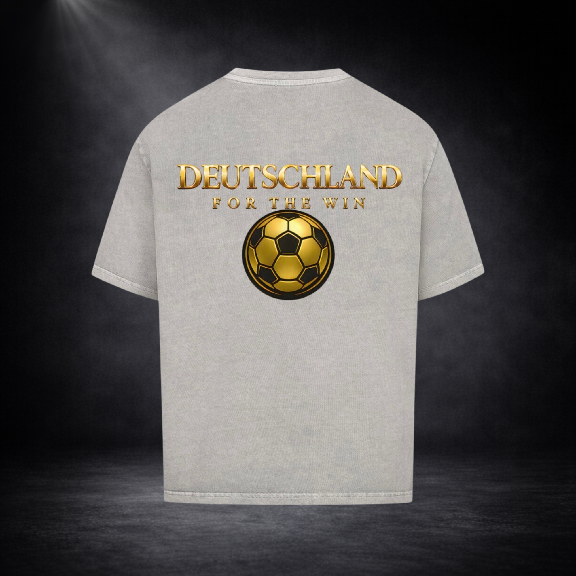 Hellgraues Oversized T-Shirt mit großem goldenen Rückenprint „DEUTSCHLAND FOR THE WIN“ und stilisiertem goldenen Fußball, vor dunklem Studio-Hintergrund im hochwertigen Premium-Look