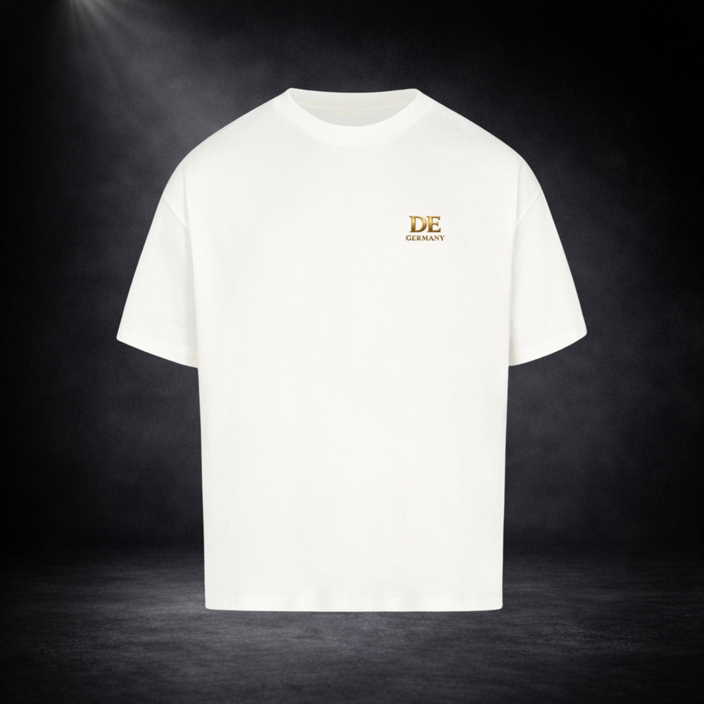 Weißes Oversized T-Shirt mit kleinem goldenen „DE Germany“ Logo auf der Brust, freigestellt vor dunklem Studio-Hintergrund im minimalistischen Premium-Look
