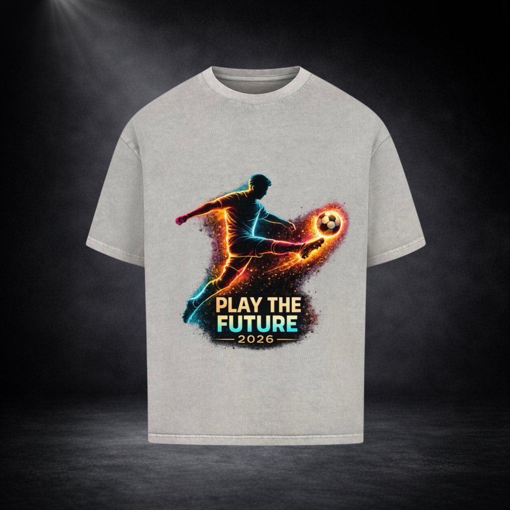 Graues Oversized T-Shirt mit leuchtendem Fußballspieler-Print in Neonfarben und dem Schriftzug „Play the Future 2026“ vor dunklem Studio-Hintergrund