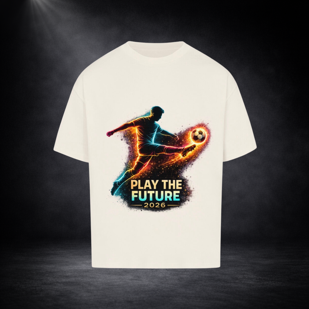 Beiges Oversized T-Shirt mit leuchtendem Fußballspieler-Print in Neonfarben und dem Schriftzug „Play the Future 2026“ vor dunklem Studio-Hintergrund