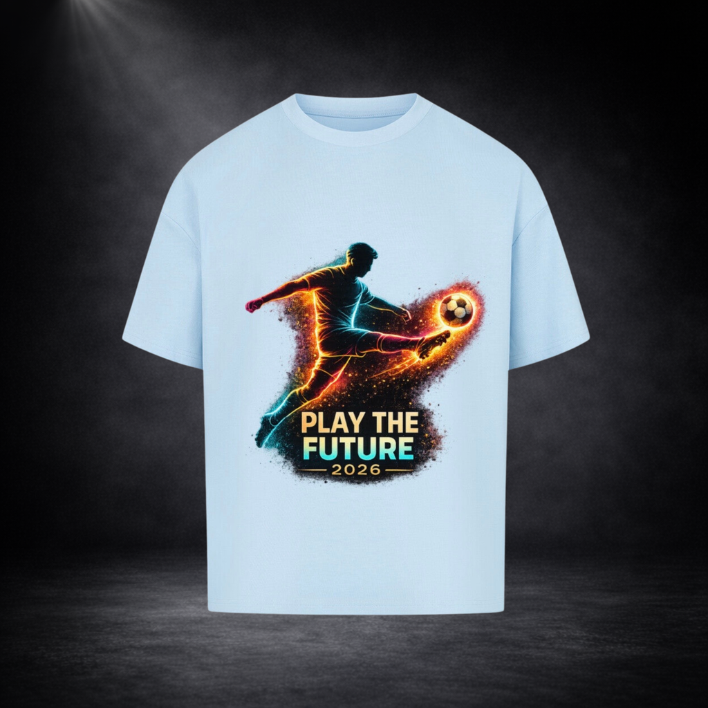 Hellblaues Oversized T-Shirt mit leuchtendem Fußballspieler-Print in Neonfarben und dem Schriftzug „Play the Future 2026“ vor dunklem Studio-Hintergrund