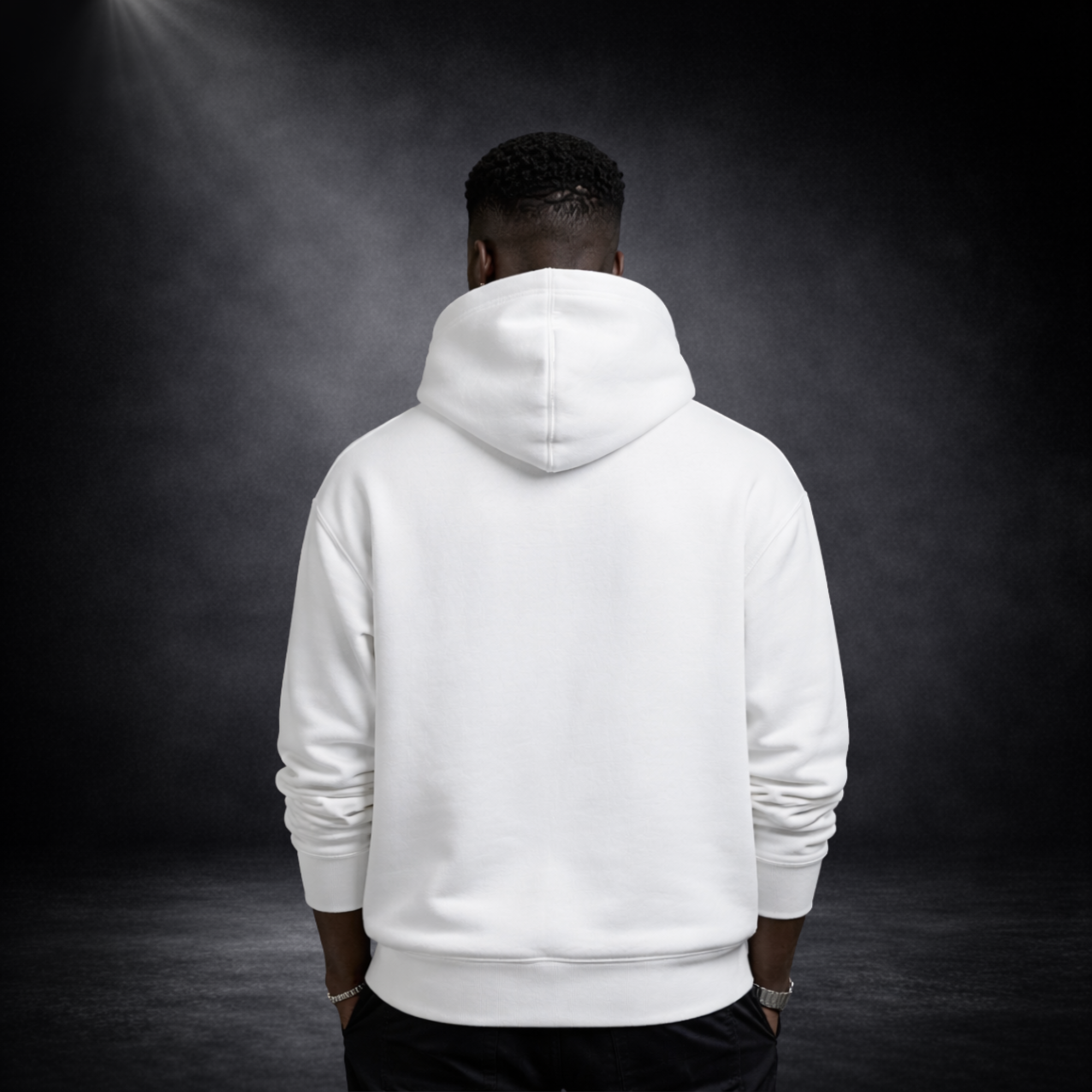 Rückansicht eines Models im weißen Hoodie ohne Druck, vor dunklem Studio-Hintergrund mit Spotlight
