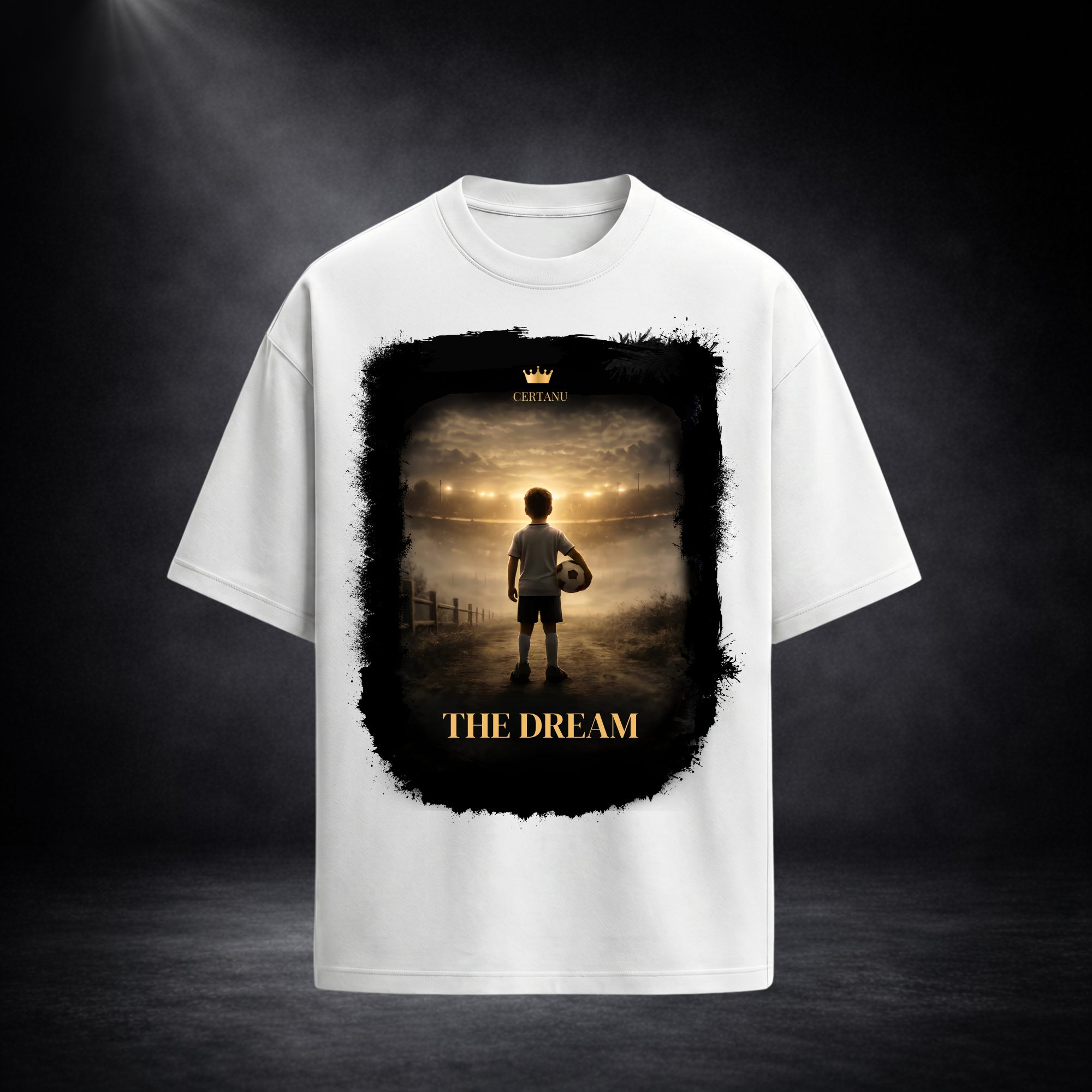 Weißes Oversized T-Shirt von CERTANU mit dem emotionalen Frontdesign „THE DREAM“. Das Motiv zeigt einen jungen Fußballspieler mit Ball, der auf ein hell erleuchtetes Stadion in der Ferne blickt und den Traum vom Profifußball symbolisiert. Warme Goldtöne, dramatische Lichtstimmung und ein künstlerischer schwarzer Rahmen verleihen dem Design eine inspirierende und hochwertige Optik. Präsentiert vor einem dunklen Premium-Studiohintergrund mit Fokus auf das großflächige Motiv und den modernen Oversized-Schnitt.