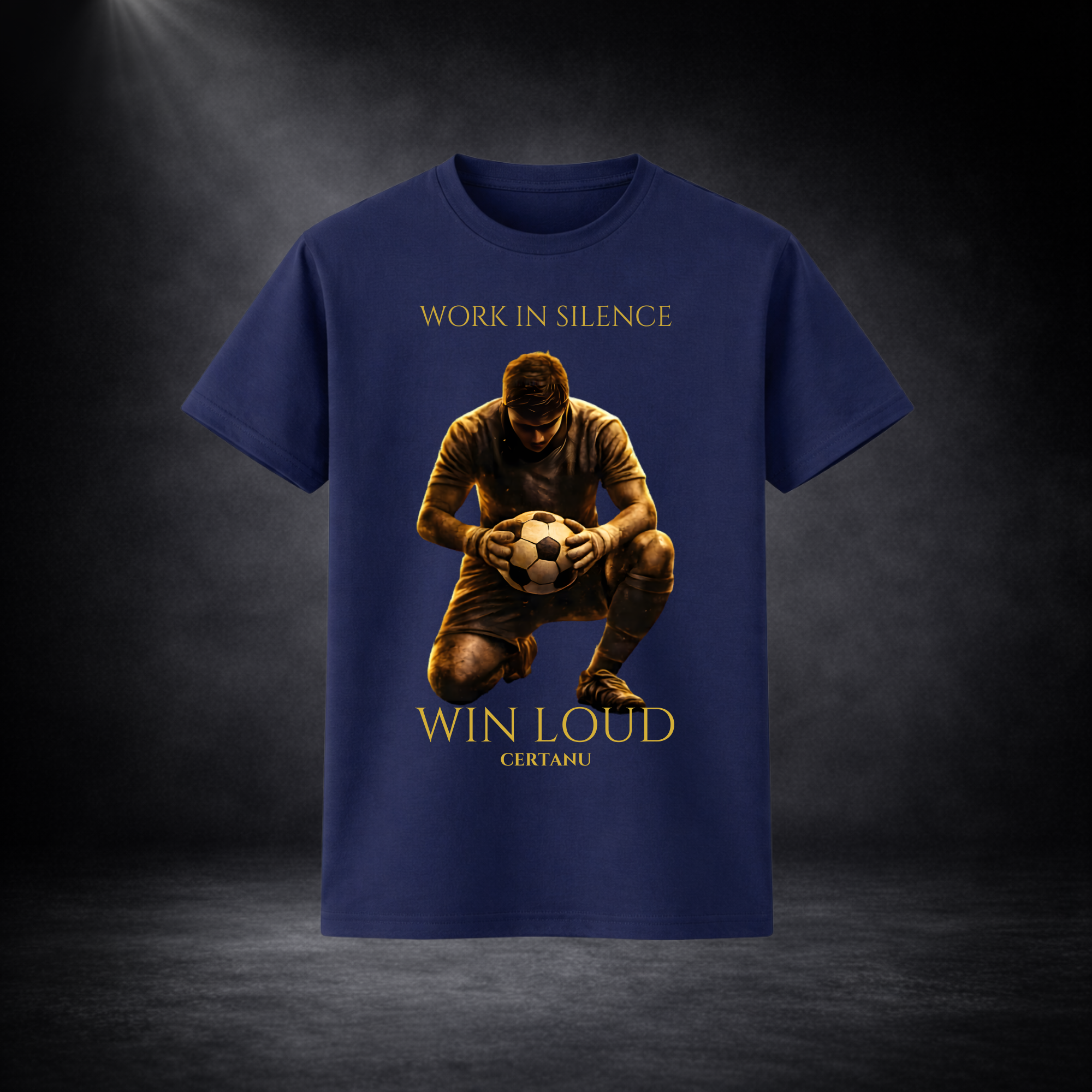 Blaues T-Shirt mit großem Frontprint: kniender Fußballspieler mit Ball und goldener Schrift „Work in Silence – Win Loud“, vor dunklem Studio-Hintergrund