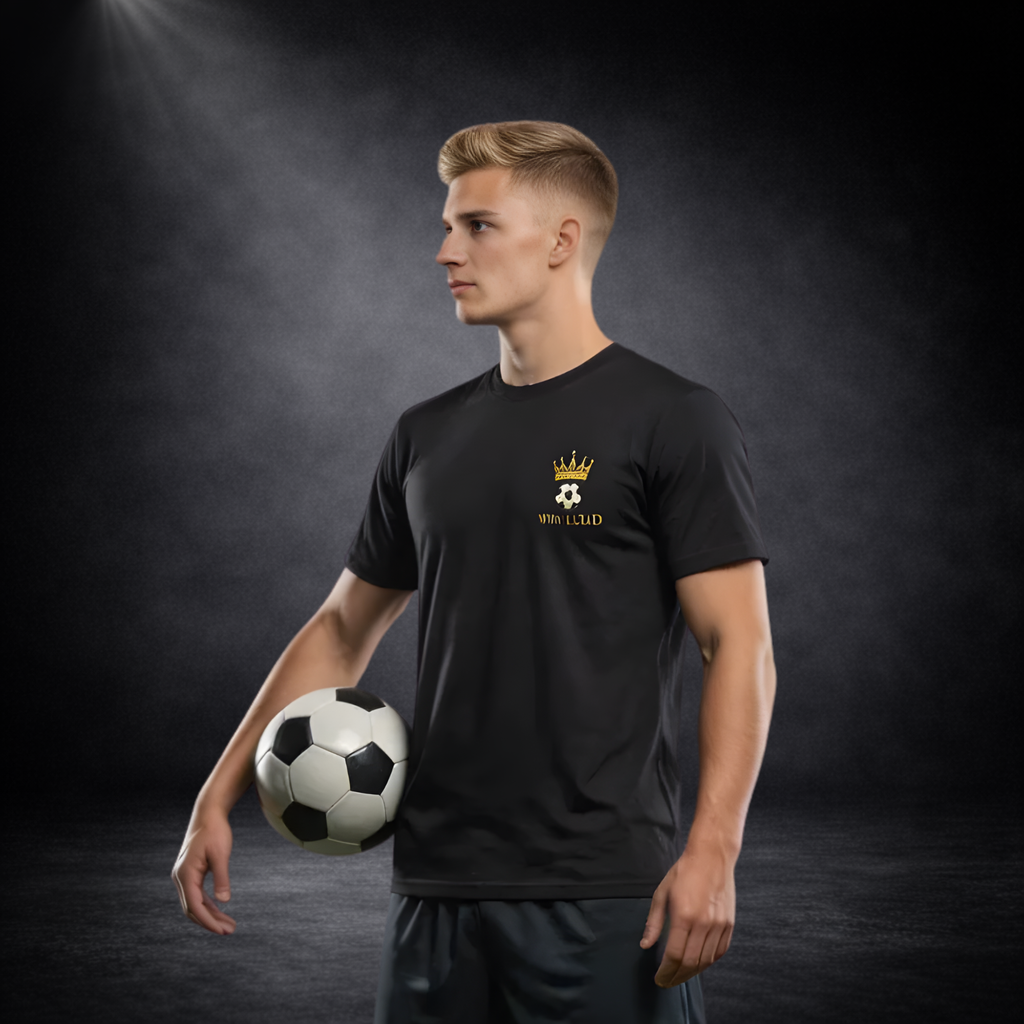 Junger Mann im Seitenprofil trägt ein schwarzes T-Shirt mit goldenen Kronen-Fußball-Logo und „WIN LOUD“ Schriftzug und hält einen Fußball unter dem Arm vor dunklem Studio-Hintergrund
